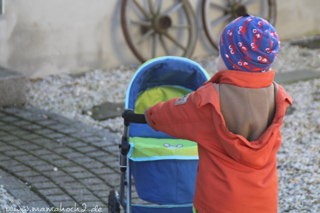 junge mit puppenwagen